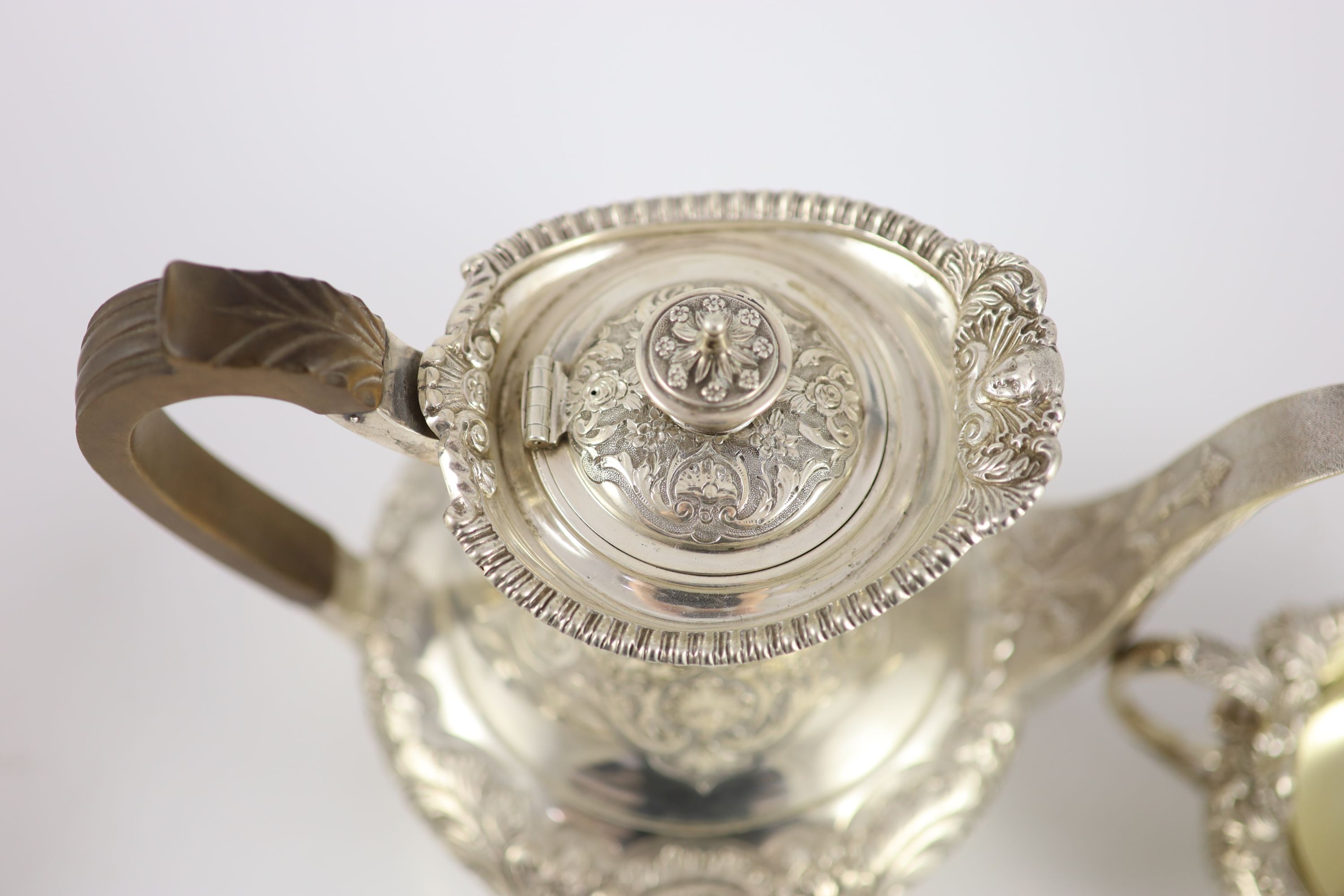 An Edwardian embossed silver circular four piece tea and coffee service by Edward Barnard & Sons Ltd